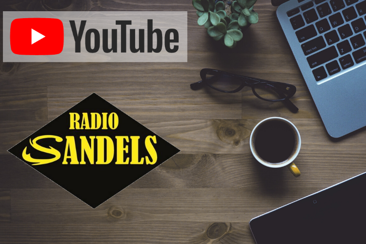 Pöydällä läppäri, tabletti, kahvikuppi ja silmälasit. YouTuben ja Radio Sandelsin logo.