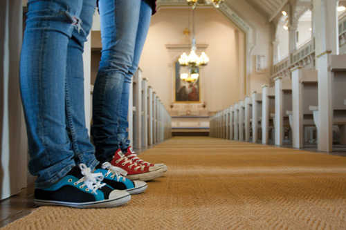 Kahden nuoren jalat kirkon käytävällä.